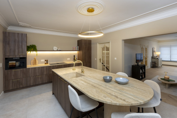 Maatwerkkeuken met warm hout en Travertin werkblad. Tijdloos design met hoogwaardige afwerking en natuurlijke materialen